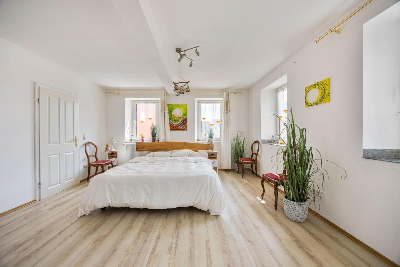 Gemütliches Zimmer mit Holzofen und weißer Bettwäsche