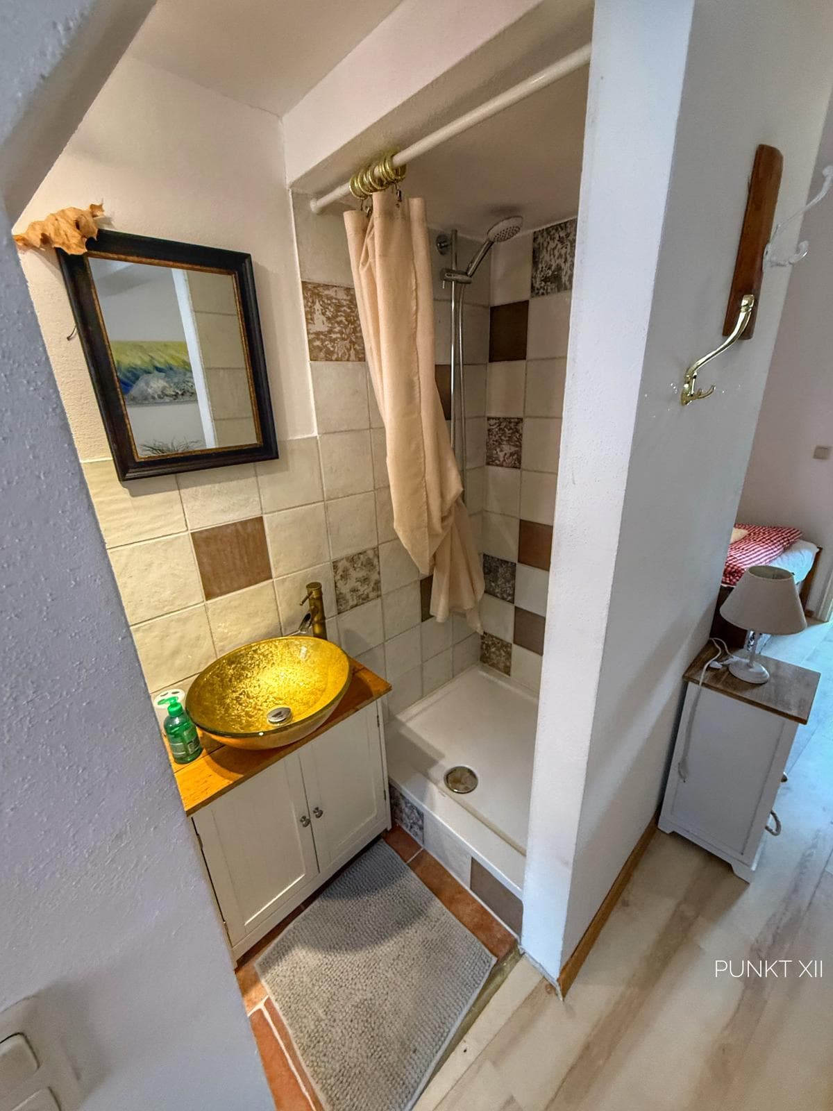 Bad der Wohnung W6 mit goldener Waschschale und Dusche